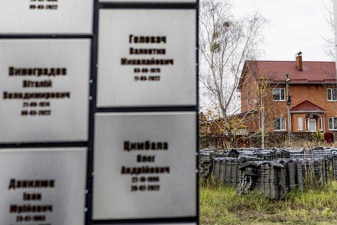 Hiša družine, ki se je v Bučo leta 2014 preselila iz Donbasa, stoji tik za grobnico. Na fotografiji je hiša, na plošči pa so imena in datumi smrti matere in obeh otrok.  | Foto: Ana Kovač