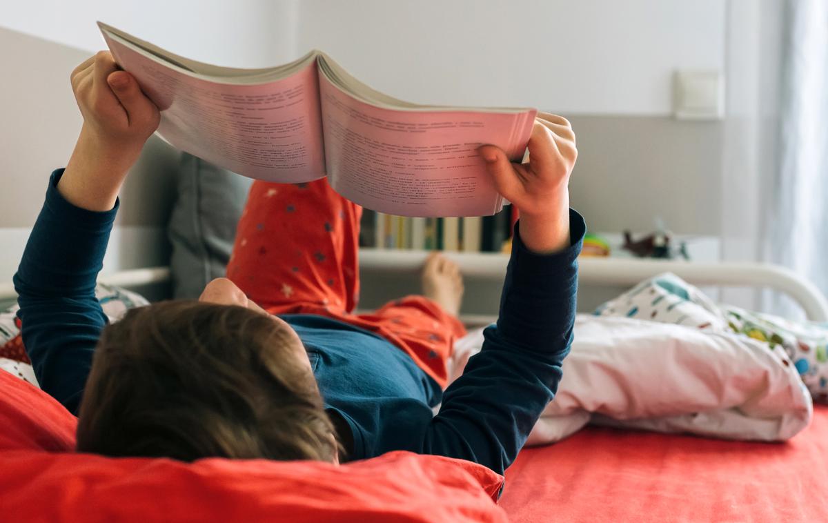 deček, knjiga, branje | Raziskava je pokazala, da slovenska dekleta še vedno dosegajo nekoliko boljše rezultate kot dečki, upad dosežkov pa je pri obeh spolih enak. | Foto Getty Images