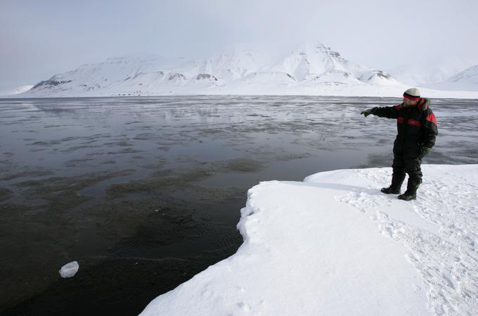 Nemec Andreas Umbreit, ki v norveškem arktičnem mestu Longyearbyen živi že skoraj 30 let, kaže na odprto morje, kjer je bil nekoč led. | Foto: Reuters