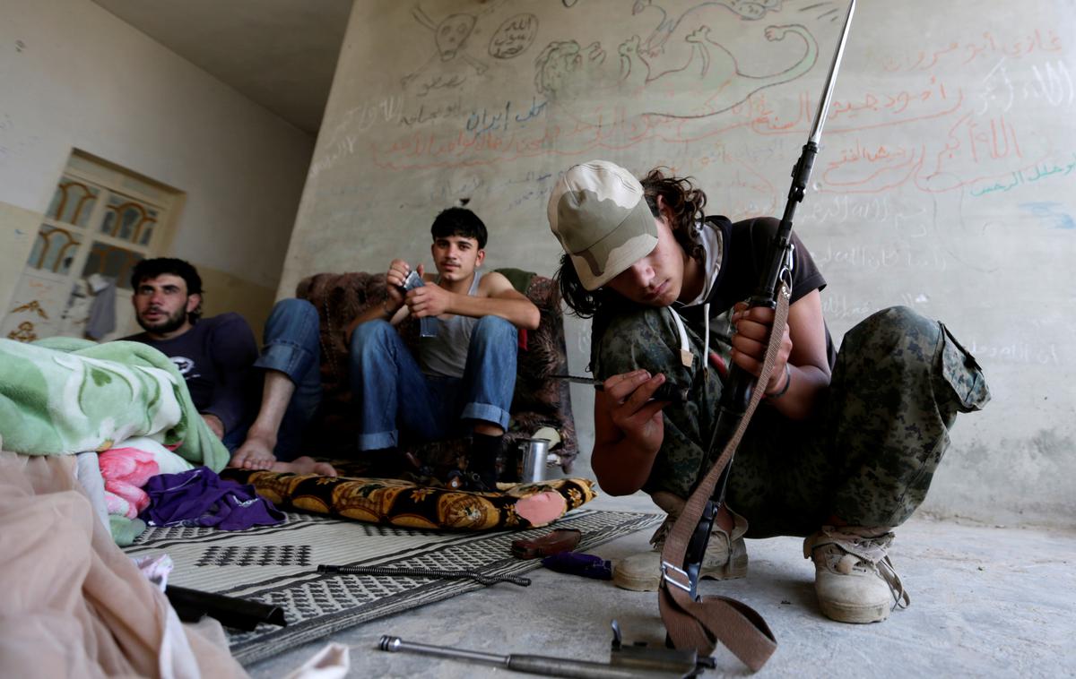Al Furqan | Pripadnik skrajne skupine al Furkan med vzdrževanjem svojega orožja.  | Foto Reuters