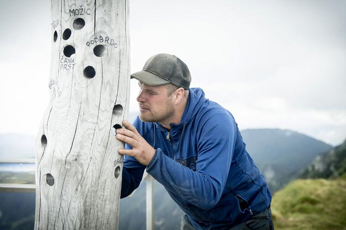 Vodja smučišča na Soriški planini Domen Pinter prikaže uporabo lesenega daljnogleda, ki ga je izdelal Vojko Debeljak.  | Foto: Ana Kovač