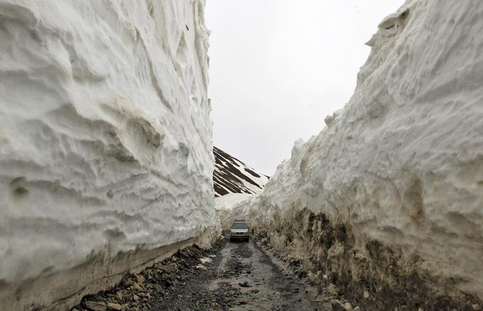 Snežni zidovi so nemalokrat tudi v maju še vedno višji od tovornjakov.  | Foto: Reuters