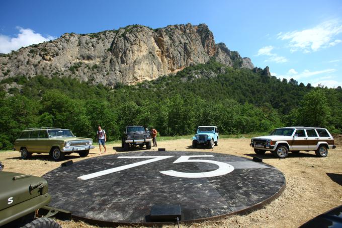 Črn lesen podest z veliko številko 75, naokrog pa starodobniki znamke jeep. Osem jih je bilo. Vsak nekaj posebnega, nek mejnik v zgodovini znamke. | Foto: Vinko Kernc