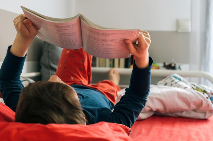 deček, knjiga, branje | Raziskava je pokazala, da slovenska dekleta še vedno dosegajo nekoliko boljše rezultate kot dečki, upad dosežkov pa je pri obeh spolih enak. | Foto Getty Images